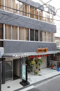 a grey building with a sign in front of it at Hotel Neo World in Osaka