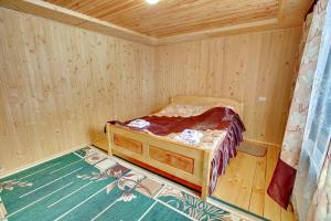 a small wooden room with a bed in it at Medova Hata in Mykulychyn +31 photos
