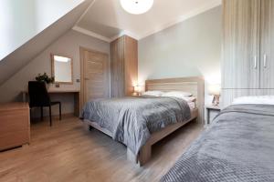1 dormitorio con cama y escritorio con espejo en Apartamenty Sun & Snow Lipki Park Zakopane, en Zakopane