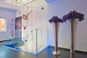 two vases with purple flowers in a room at G Design Hotel in Ljubljana