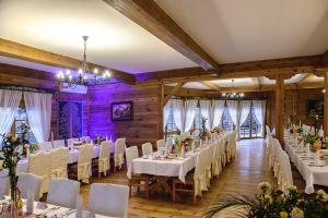 un salón de banquetes con mesas blancas y sillas blancas en Hotel Lotos, en Woskrzenice Duże