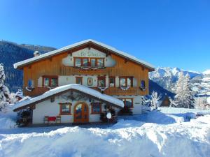 a large building with snow on the ground at Hotel Garni la Stua in Selva di Cadore