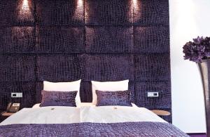a bedroom with a large bed with blue pillows at G Design Hotel in Ljubljana
