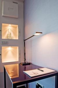 a desk with a lamp and a book on it at G Design Hotel in Ljubljana