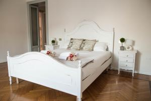 a white bed in a bedroom with a wooden floor at Adelaide Central Apartment in Milan