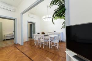 a white dining room with a table and chairs at Adelaide Central Apartment in Milan
