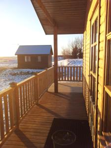 a porch of a house with snow on the ground at Egilsstaðir 1 Guesthouse in Villingaholt