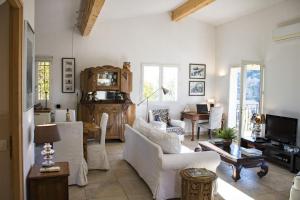 a living room with white furniture and a table at La Muse du Paradis in Montauroux