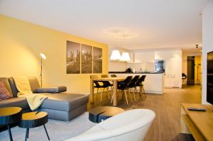 ein Wohnzimmer und eine Küche mit einem Sofa und einem Tisch in der Unterkunft Apartment Ankebälleli - GriwaRent AG in Interlaken