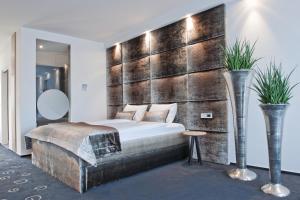 a bedroom with a large bed and a wooden wall at G Design Hotel in Ljubljana