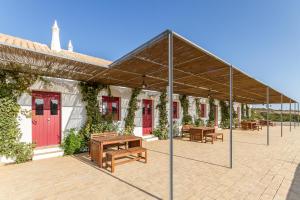 - un pavillon avec des bancs et des tables sur une terrasse dans l'établissement Quinta da Várzea do Farelo, à Mexilhoeira Grande