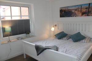 a white bed in a room with a window at Küstenzauber in Schönhagen