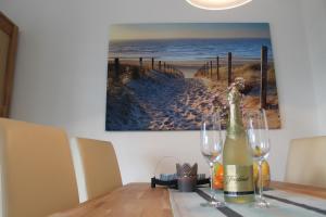 a table with two glasses and a bottle of wine at Küstenzauber in Schönhagen