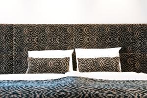 a bed with two pillows and a headboard at G Design Hotel in Ljubljana