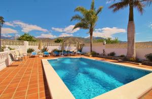 einen Pool in einem Garten mit Palmen in der Unterkunft Villa Jeromo SpainSunRentals 1004 in Nerja