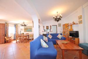 ein Wohnzimmer mit einem blauen Sofa und einem Tisch in der Unterkunft Villa Jeromo SpainSunRentals 1004 in Nerja