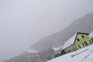 a building in the snow in front of a mountain at Privát Miško in Levoča