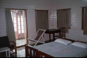 a bedroom with a bed and a table and a desk at Broad Lands in Chennai