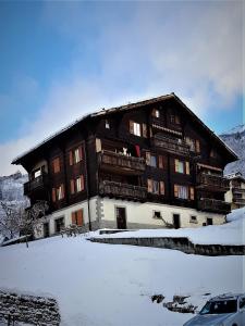 a large building with snow in front of it at Alpen-Sonne in Sankt Niklaus