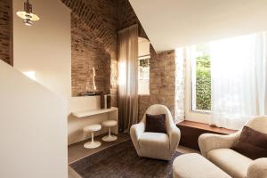 a living room with two chairs and a window at Nun Assisi Relais & Spa Museum in Assisi +65 photos