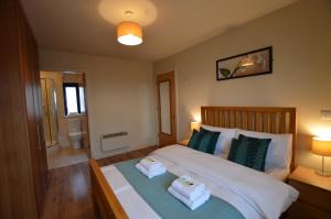 a bedroom with a bed with two towels on it at Milligan Court Townhouses in Sligo