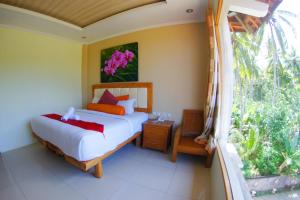 a bedroom with a bed and a window at Crystal Beach Bali in Candidasa