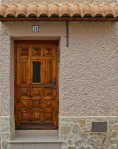 a wooden door on a building with a sign on it at Casa Rural Guadiela II in San Pedro Palmiches