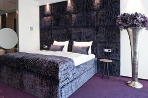 a bedroom with a bed and a vase with flowers at G Design Hotel in Ljubljana