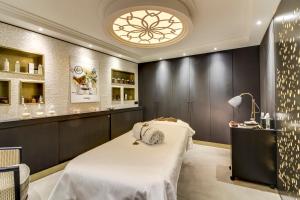 a spa room with a bed and a chandelier at Castelbrac Hotel & Spa in Dinard