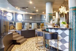 a bar with blue and gold stools in a salon at Castelbrac Hotel & Spa in Dinard