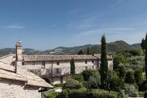 a large stone building with a clock tower on it at Nun Assisi Relais & Spa Museum in Assisi