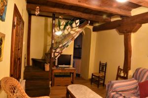un soggiorno con scala e televisore di Casa Rural El Camino a Montemayor de Pililla