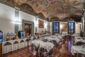 un salón de banquetes con mesas blancas y techo en Hotel Paris en Florencia