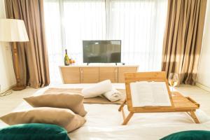 een woonkamer met een tv en een tafel en kussens bij Hotel Kadmo by Aycon in Budva