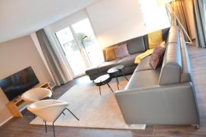 un soggiorno con divano e TV di Apartment Edelwyss - GriwaRent AG a Interlaken