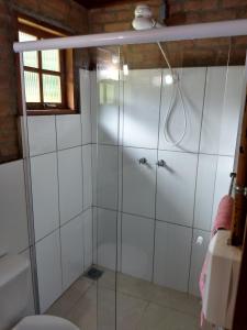 eine Dusche mit Glastüren in einem Badezimmer in der Unterkunft Casa do Bosque in Visconde De Maua