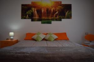 um quarto com uma cama com um quadro na parede em suite the natural color em Selargius