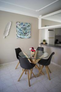 a dining room with a glass table and two chairs at Casa del Mar in Playa de San Juan