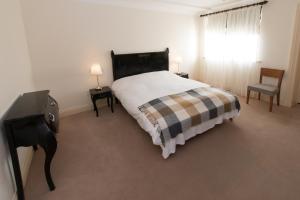 1 dormitorio con 1 cama, 1 silla y 1 ventana en Connemara Lake Hotel en Oughterard