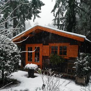 a log cabin with snow on the roof of it at Bed En - of zonder - Breakfast Putten in Putten