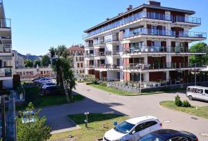 duży budynek z samochodami zaparkowanymi na parkingu w obiekcie Apartamenty Na Wyspie - Baltic Park - Apartamenty z sypialnią i parkingiem - ul Uzdrowiskowa 24-34 w Świnoujściu