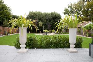 two white vases with plants in a garden at The Park in Weston-super-Mare