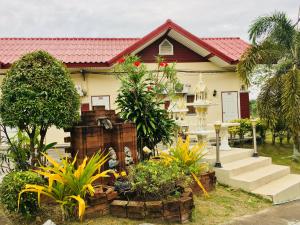 una casa con algunas plantas delante de ella en Purinplace, en Pluak Daeng