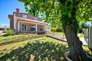een huis met een boom ervoor bij Stylish & luxury villa with pool, biliard, extra pool heating available - WiiBuk in Pula