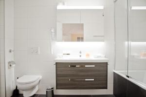 La salle de bains blanche est pourvue de toilettes et d'un lavabo. dans l'établissement Apartment Gänseblüemli - GriwaRent AG, à Interlaken