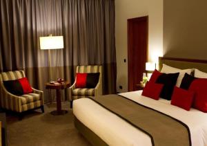 Habitación de hotel con 1 cama y 2 sillas en Hotel Dighton, en Oliveira de Azemeis