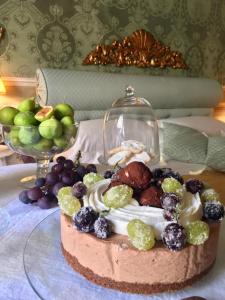 a cake on a glass plate with fruit on a table at Residenza Dei Ricci in Chiusi