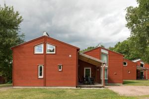 a barn style house with a red exterior at First Camp Västerås-Mälaren in Västerås