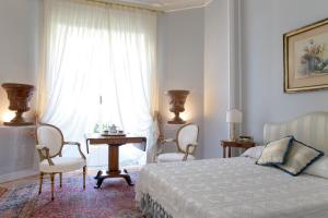 a bedroom with a bed and two chairs and a window at Suite Oriani in Rome