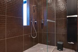 a bathroom with a shower with brown tiles at G Design Hotel in Ljubljana